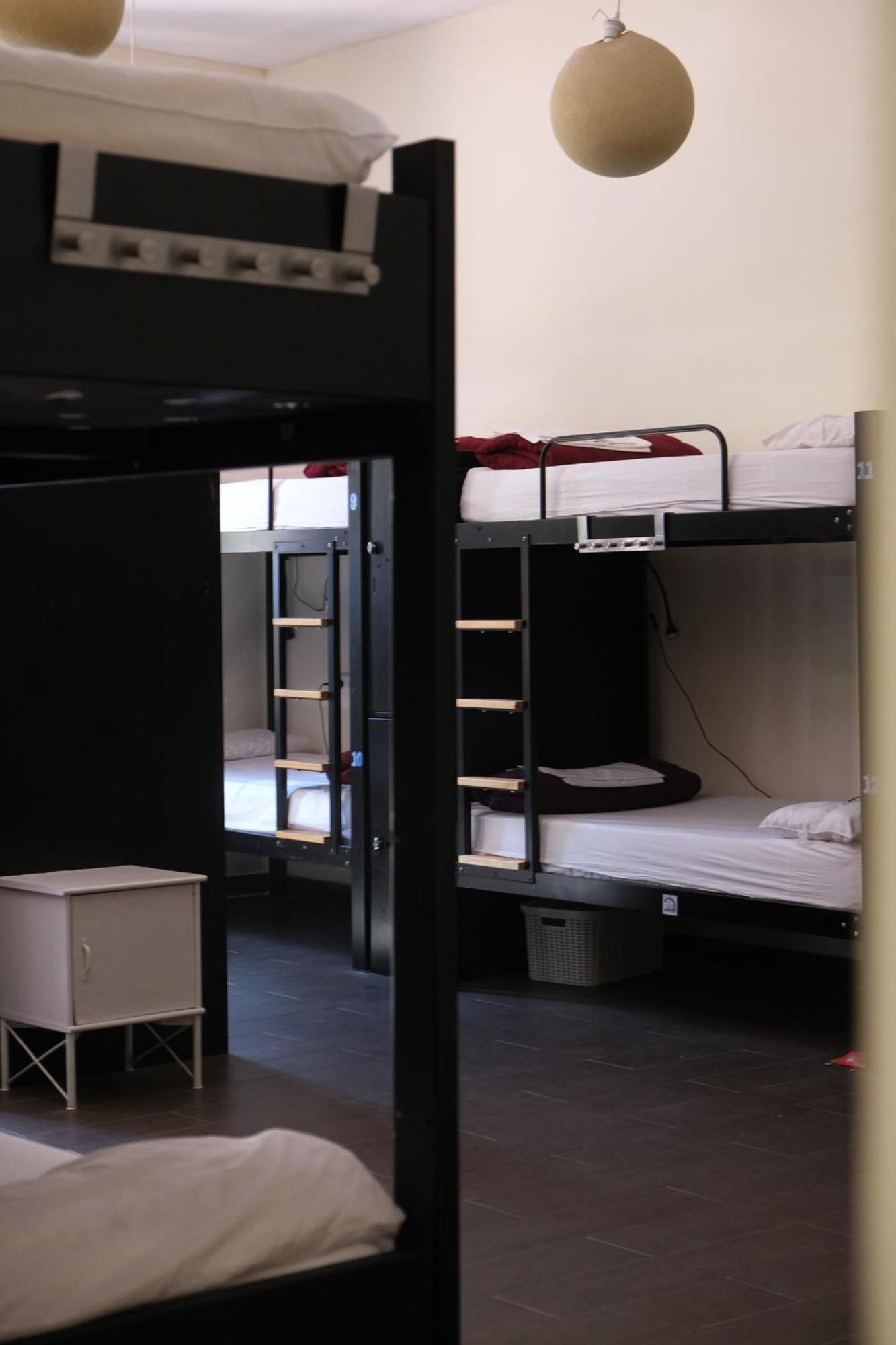 Cama individual en dormitorio compartido de 16 camas